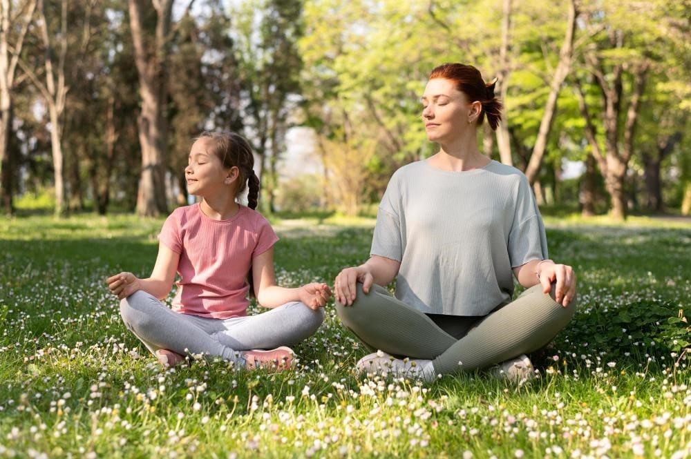 Two different age people doing meditation in park for health benefits