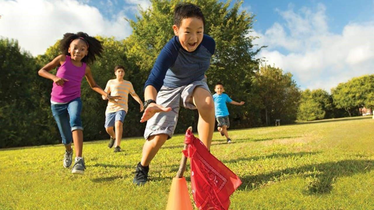 Outdoor Fitness Games for Kids That Actually Tire Them Out 3 kids playing Capture the Flag outdoor game